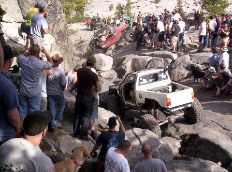 1989 Ford Bronco - Spectators gather to watch an off-road pickup truck tackle a challenging rocky course.
