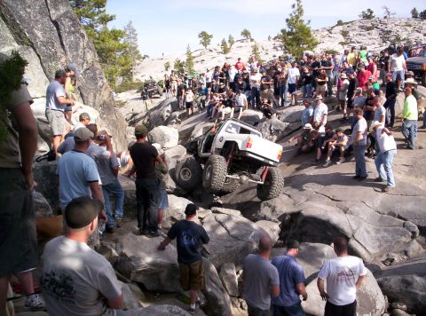 1989 Ford Bronco - A crowd watches as an off-road vehicle navigates a challenging rocky terrain.