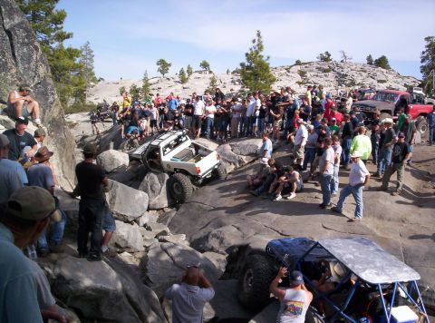 1989 Ford Bronco - A crowd watches as off-road vehicles tackle a challenging rocky course.