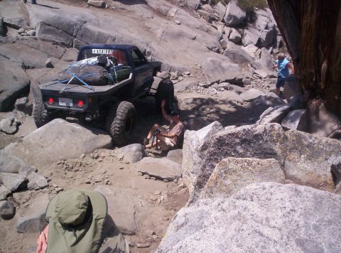 1989 Ford Bronco - Off-road truck tackling a challenging rocky path with people observing the action.