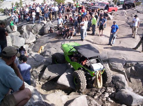 1989 Ford Bronco - A group watches an off-road buggy traverse a rocky terrain.