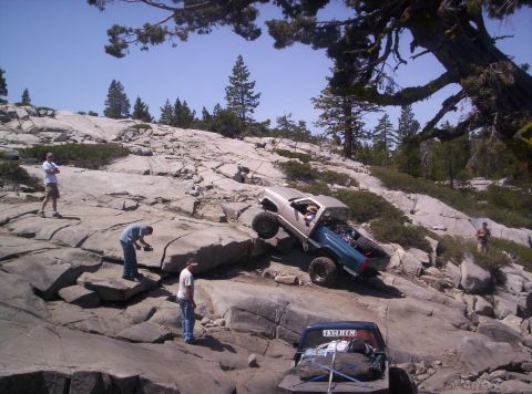 1989 Ford Bronco - Off-road vehicles tackle a challenging rocky landscape, with one truck climbing and another parked below.