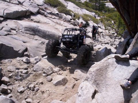1989 Ford Bronco - This heavily modified off-road buggy navigates a challenging rocky terrain, its extreme suspension and tire capabilities.