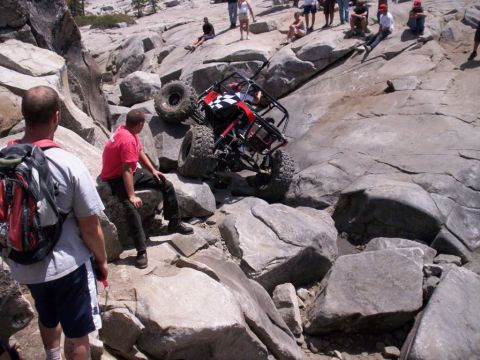 1989 Ford Bronco - An off-road buggy navigates a challenging rocky terrain with spectators observing the action.