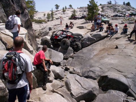 1989 Ford Bronco - Spectators watch an off-road buggy navigate a challenging rocky terrain.