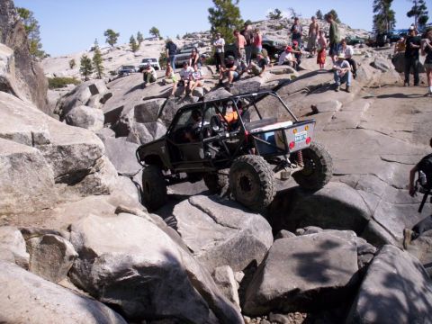 1989 Ford Bronco - An extreme off-road vehicle navigates a challenging rocky course with onlookers present.