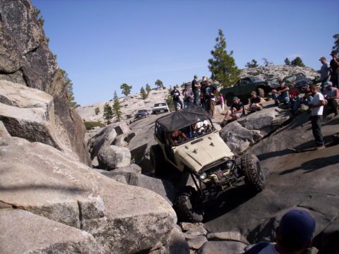 1989 Ford Bronco - An off-road vehicle navigates a rocky incline while spectators observe the challenging terrain.