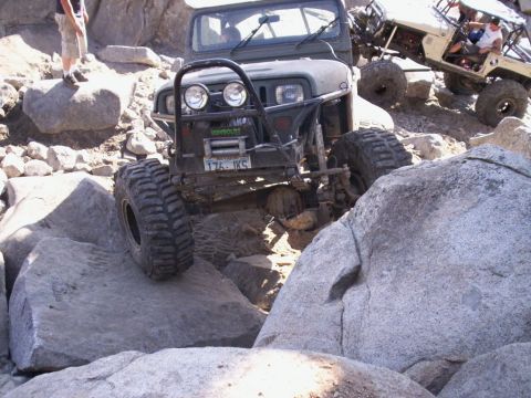 1989 Ford Bronco - Off-road Jeep Wrangler navigating a rocky trail with another vehicle in the background.
