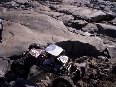 1989 Ford Bronco - A custom-built off-road buggy navigates a challenging rocky terrain.