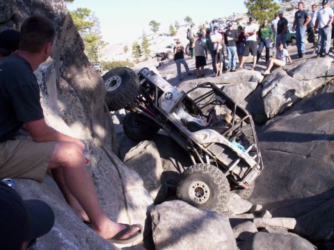 1989 Ford Bronco - A heavily modified off-road vehicle navigates a rocky terrain with spectators observing the action.