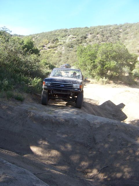 1991 Ford Bronco - This Ford F-Series truck navigates a challenging off-road course on a sunny day.