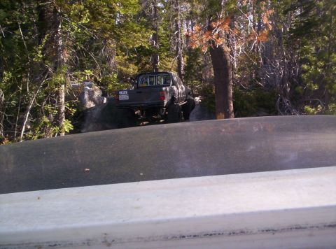 1989 Ford Bronco - A pickup truck navigates rocky terrain surrounded by trees.