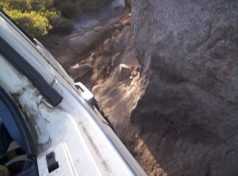 1989 Ford Bronco - Navigating a challenging rocky path with a large boulder close by.