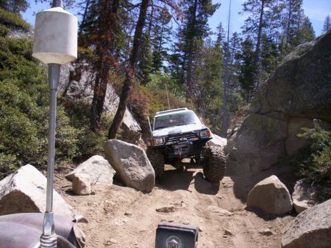 1989 Ford Bronco - This modified SUV tackles a challenging off-road trail, demonstrating its capability on terrain.