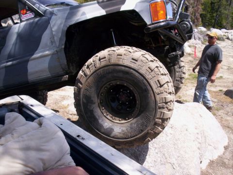 1989 Ford Bronco - Off-road vehicle with aggressive tires navigating rocky terrain.