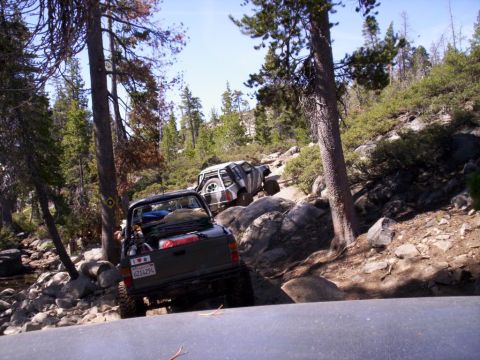 1989 Ford Bronco - Off-roading adventure on a challenging, rocky mountain trail with two trucks.