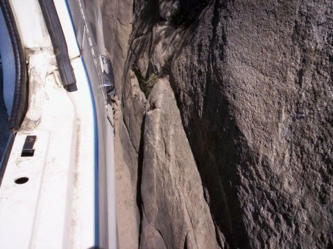 1989 Ford Bronco - The interior of a vehicle is seen pressed against a large rock formation.