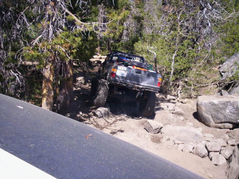 Rear view of a lifted 1989 Ford Bronco off-roading on a rocky trail