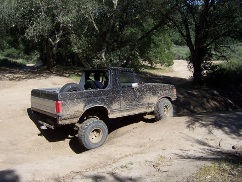 1991 Ford Bronco - 1991 Ford Bronco navigating a dirt path during an off-road excursion.