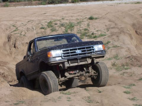 1991 Ford Bronco - Ford Bronco navigating challenging off-road terrain during a weekend event.