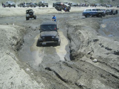 1987 Suzuki Samurai - Off-roading event with multiple vehicles tackling a challenging muddy course.