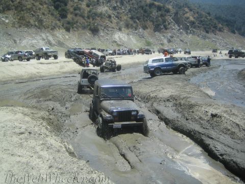 1987 Suzuki Samurai - Multiple off-road vehicles are stuck or maneuvering through a challenging muddy landscape.