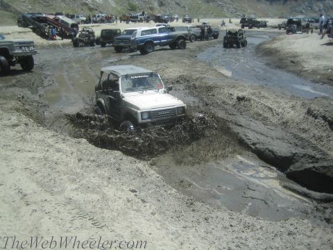 1987 Suzuki Samurai - Off-road vehicles tackle a muddy terrain, with a Suzuki Samurai prominently featured.