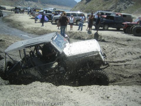 1987 Suzuki Samurai - Off-roading event with a Suzuki Samurai stuck in the mud near a body of water.