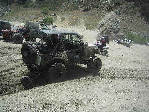 1987 Suzuki Samurai - Modified 1987 Suzuki Samurai navigating a dirt trail with other off-road vehicles present.