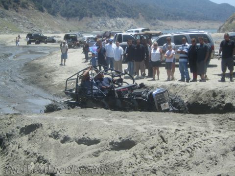 1987 Suzuki Samurai - A group of people watch a custom buggy that is stuck in the mud near a body of water.