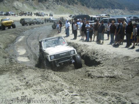 1987 Suzuki Samurai - Suzuki Samurai tackles a challenging off-road course with onlookers observing the action.