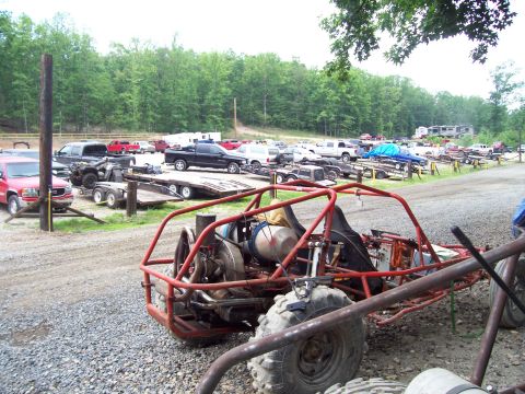 1989 Ford Bronco II - A red dune buggy is in the foreground, with many trucks and trailers visible in the background.