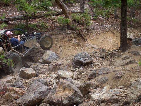 1989 Ford Bronco II - Buggy tackling a challenging off-road course with large rocks and steep inclines.