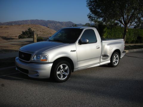1998 Ford Crown Victoria - This silver pickup truck is a 1999 Ford F-150 SVT Lightning, not a 1998 Crown Victoria.