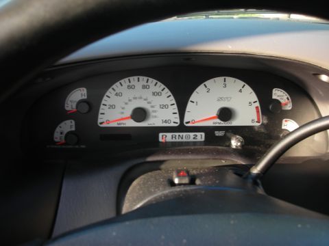 1998 Ford Crown Victoria - Close-up through the steering wheel of a white-faced SVT instrument cluster with a 140 mph speedometer, tachometer redlined at 6,000 rpm ma…