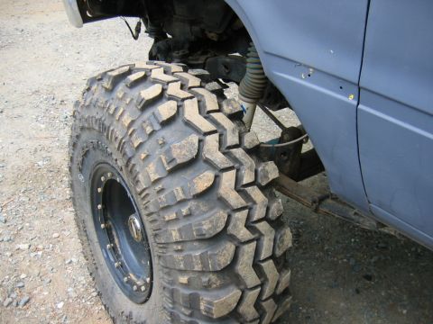 1992 Ford Mustang - Close-up of a large, knobby off-road tire and suspension components on a vehicle.