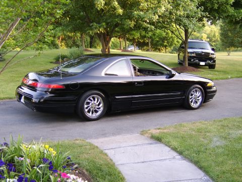 1996 Mercury Grand Marquis - Black 1996 Mercury Cougar XR7 parked on a driveway with an SUV in the background.