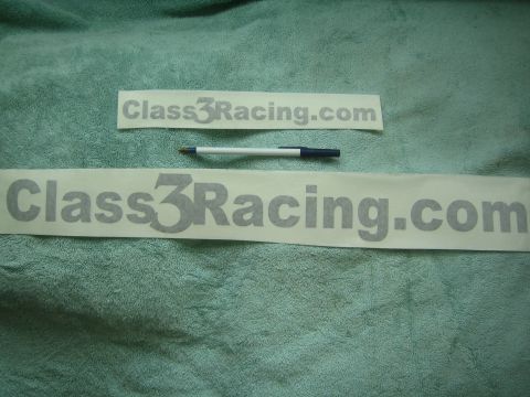 1990 Ford Bronco - Two gray 'Class3Racing.com' vinyl lettering decals of differing sizes rest on green fabric with a pen placed between them.