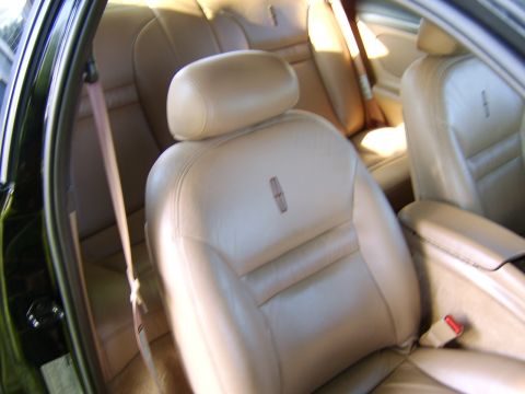 1996 Mercury Grand Marquis - The interior of a car shows tan leather seats and seatbelts.