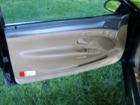 1996 Mercury Grand Marquis - Interior view of a car's tan door panel, showing the window and lock controls.