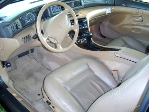 1996 Mercury Grand Marquis - The interior of a car with tan leather seats and beige carpeting is shown from the passenger side.