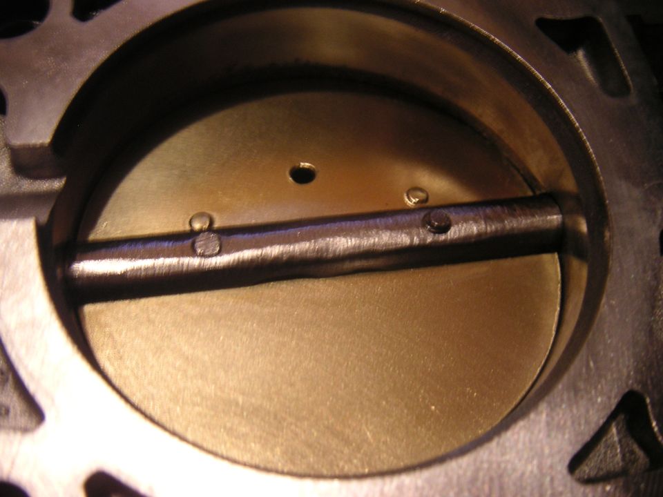 Close-up of a throttle body interior with the butterfly valve closed