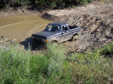 1991 Ford Bronco - This 1991 Ford Bronco is navigating a challenging muddy terrain during an off-road event.