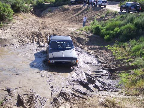 1991 Ford Bronco - Off-roading event with a 1991 Ford Bronco tackling a challenging muddy track.