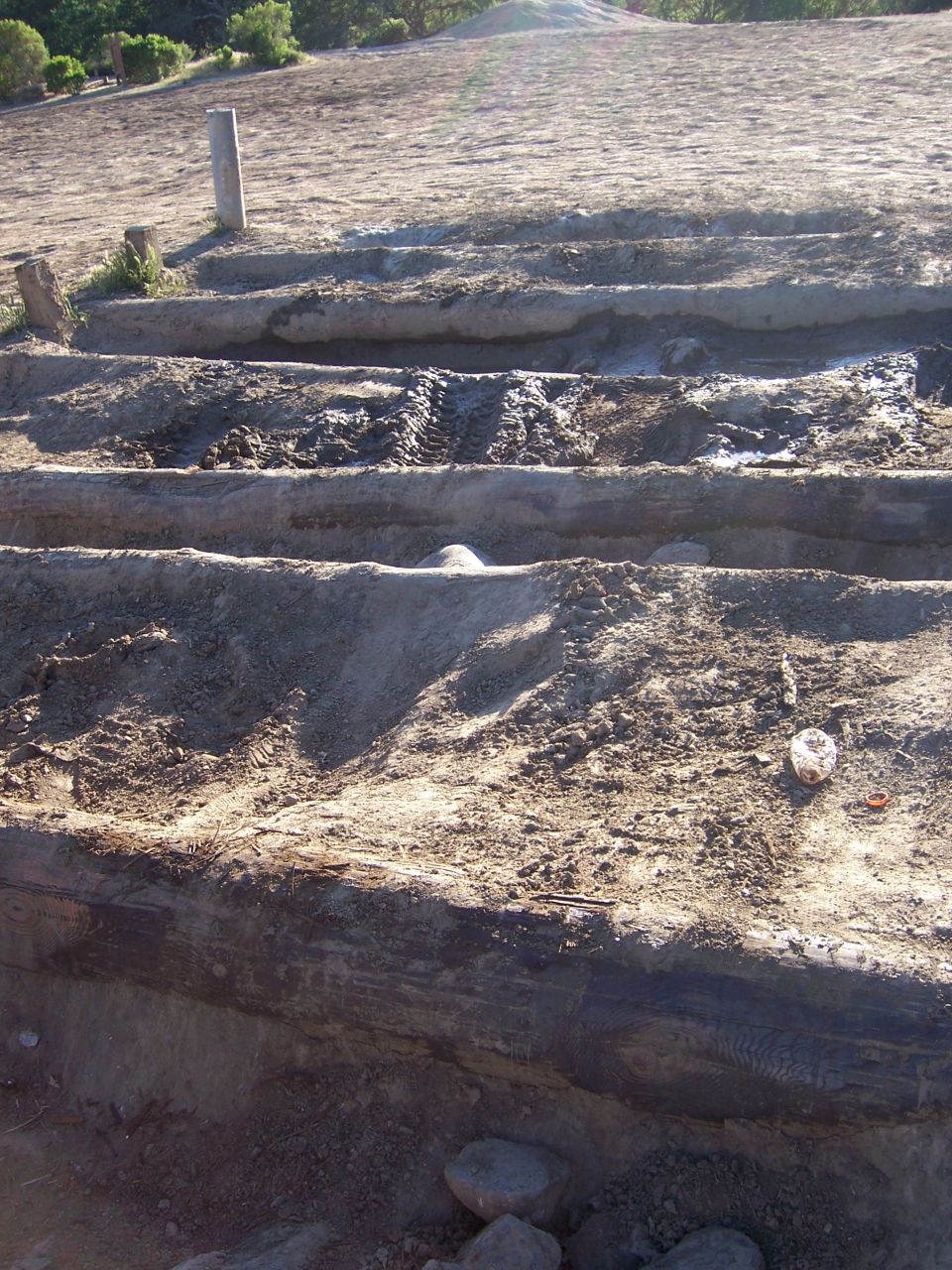 Muddy terrain with deep ruts and tire tracks, possibly from off-roading