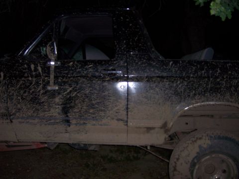 1991 Ford Bronco - This vehicle is heavily coated in mud, obscuring its make and model details.