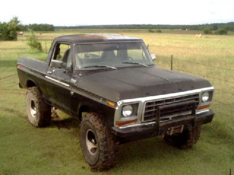 1978 Ford Bronco - A black 1978 Ford Bronco sits in a grassy field under a cloudy sky.