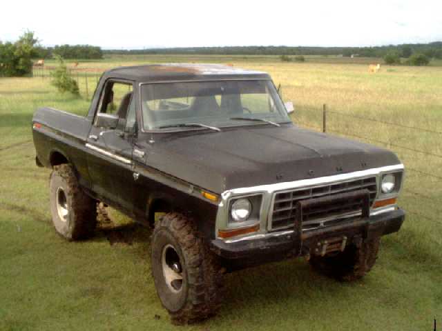 Black 1978 Ford Bronco with a brush guard and winch, viewed from the front-left