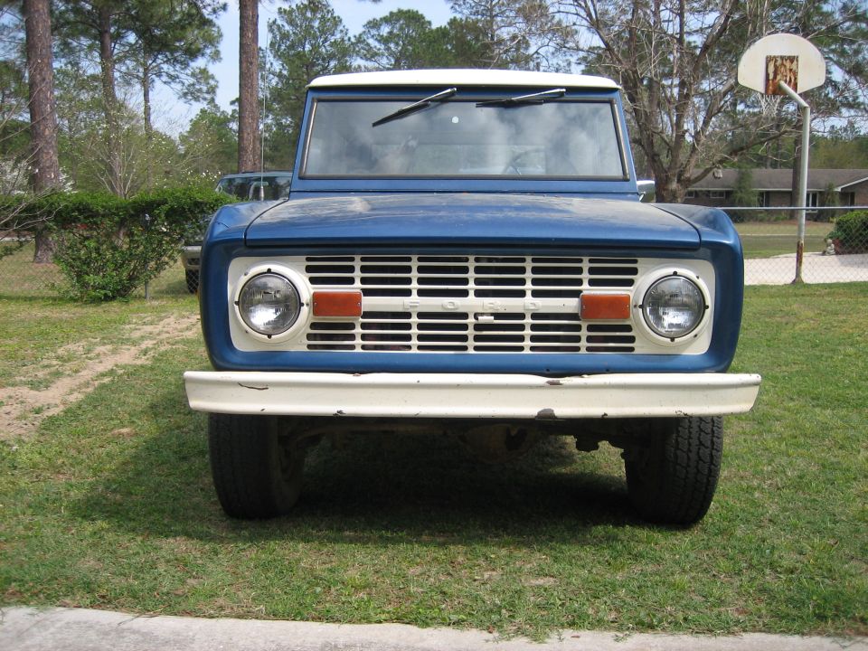 Front view of a blue and white first-generation Ford Bronco with a white grille