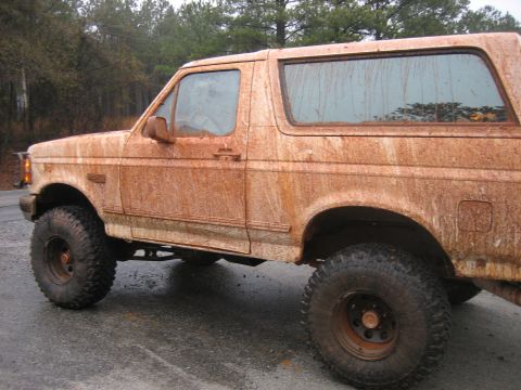 1996 Ford Bronco - This SUV is heavily covered in mud, obscuring its make and model details.